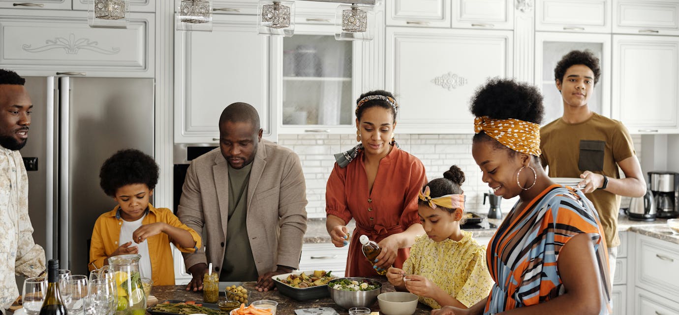 A happy family gathers in the kitchen to prepare a delicious meal together, fostering togetherness and joy.