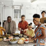 A happy family gathers in the kitchen to prepare a delicious meal together, fostering togetherness and joy.