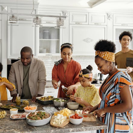 A happy family gathers in the kitchen to prepare a delicious meal together, fostering togetherness and joy.